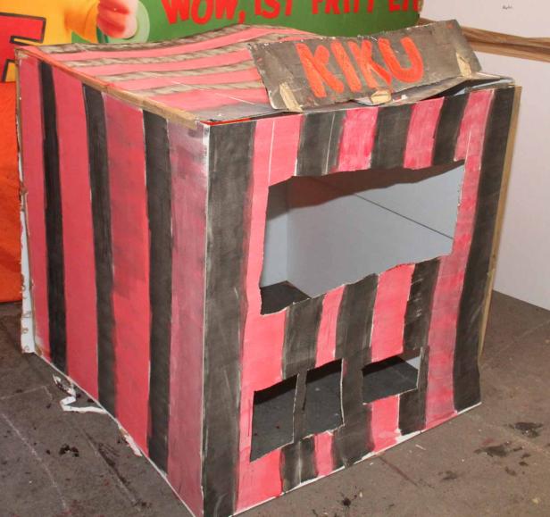 Ein rot-schwarz gestreiftes KIKU-Puppentheater aus Pappe.