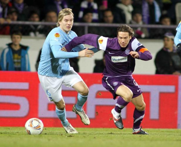 Zwei Fußballspieler kämpfen um den Ball während eines Spiels.