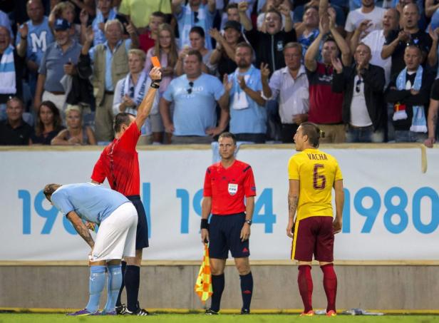 Ein Schiedsrichter zeigt einem Fußballspieler die Rote Karte.