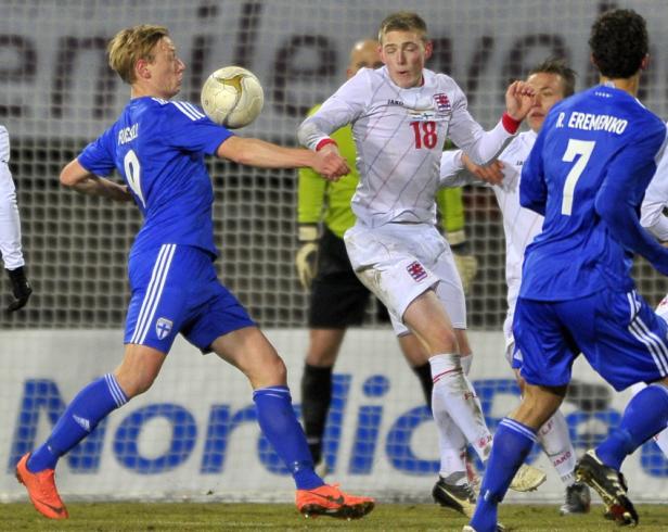 Fußballspieler kämpfen um den Ball während eines Spiels.