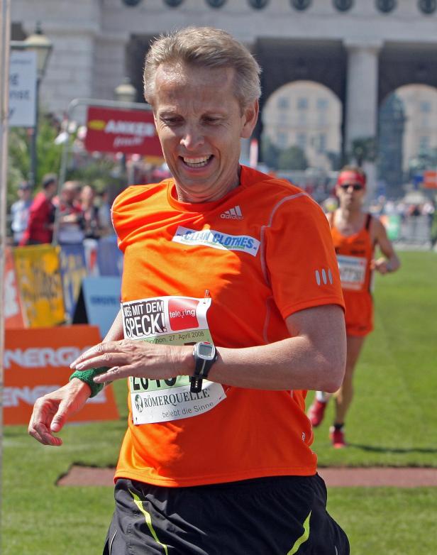 Ein Mann läuft einen Marathon in einem orangefarbenen T-Shirt.