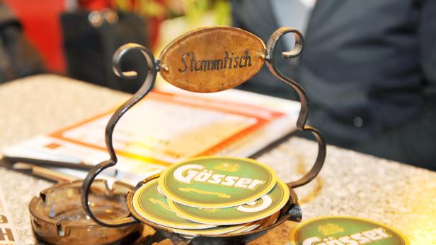 Ein „Stammtisch“-Schild über einem Stapel Bierdeckel der Marke Gösser.