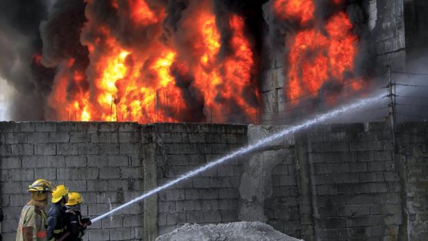 Feuerwehrleute bekämpfen einen Brand in einem Gebäude mit einem Wasserstrahl.