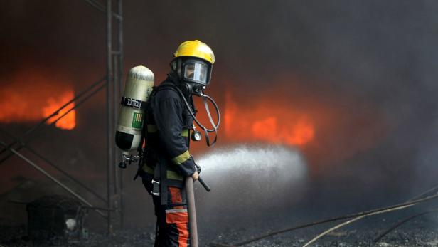 Ein Feuerwehrmann mit Atemschutzgerät löscht einen Brand.