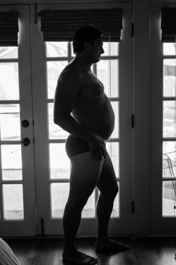 Die Silhouette eines Mannes steht vor einer Glastür.