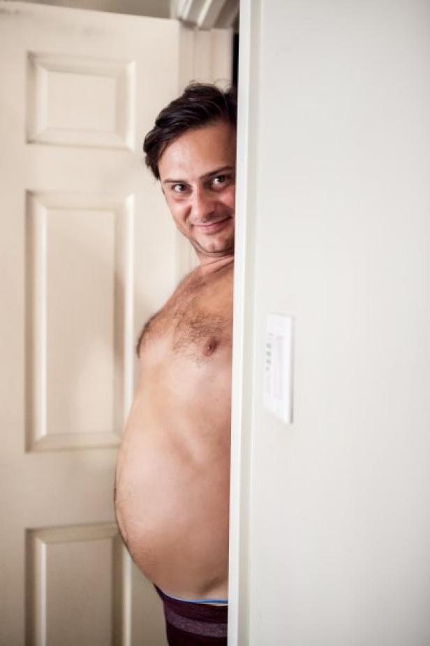 Ein Mann schaut von hinter einer Tür hervor.