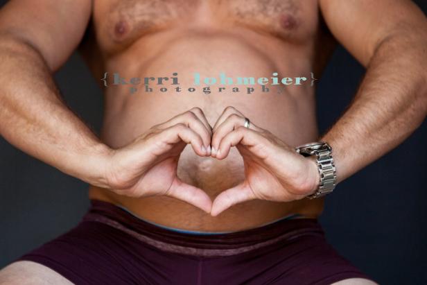 Ein Mann formt mit seinen Händen ein Herz vor seinem Bauch.