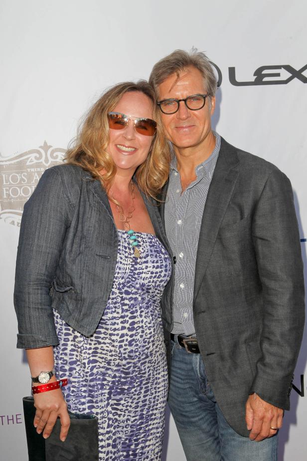 Aaron Sorkin posiert mit einer Frau auf einer Veranstaltung.