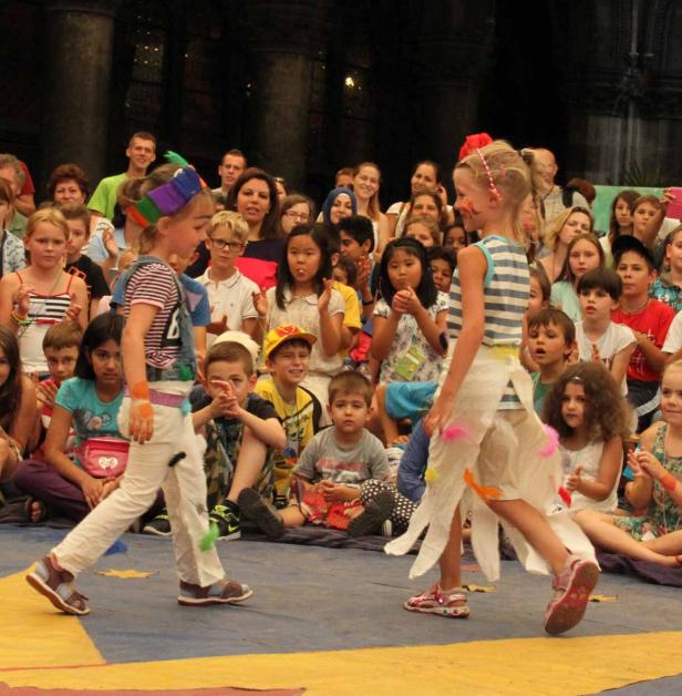 Zwei Mädchen präsentieren selbstgemachte Kostüme vor einem Publikum.