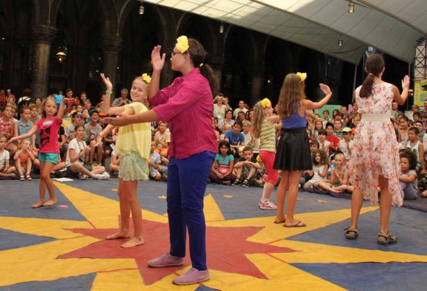 Eine Gruppe junger Mädchen führt vor einem Publikum eine Tanzdarbietung auf.