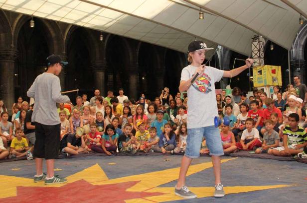 Ein Junge führt vor Publikum ein Diabolo-Spiel vor.