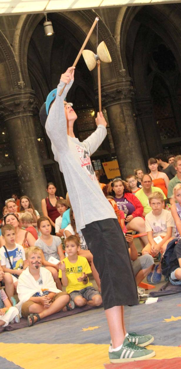 Ein junger Mann führt vor Publikum ein Diabolo-Spiel vor.