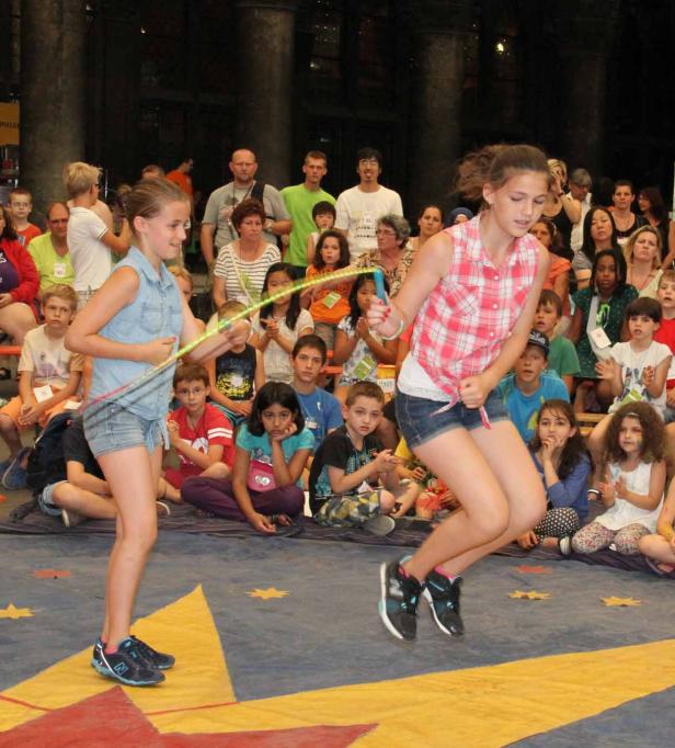 Zwei Mädchen führen vor einem Publikum Seilspringen vor.