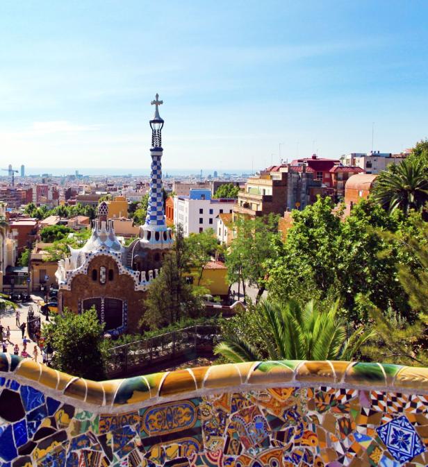 Blick über den Park Güell in Barcelona mit seinen bunten Mosaiken und fantasievollen Bauten.