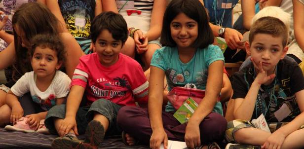 Eine Gruppe von Kindern sitzt zusammen auf dem Boden.