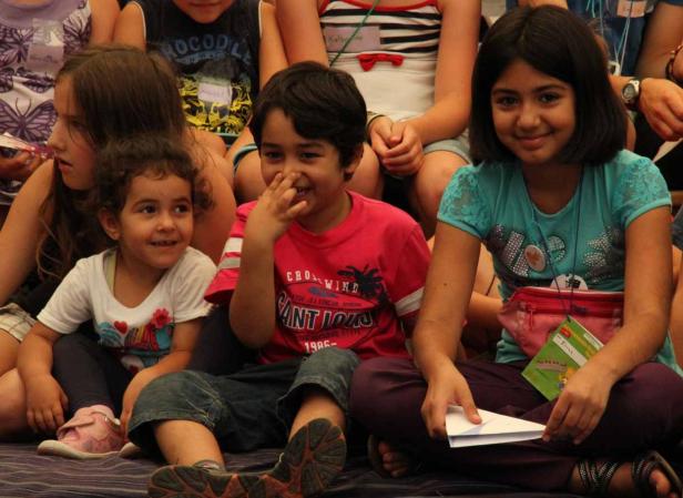Eine Gruppe von Kindern sitzt zusammen auf dem Boden.