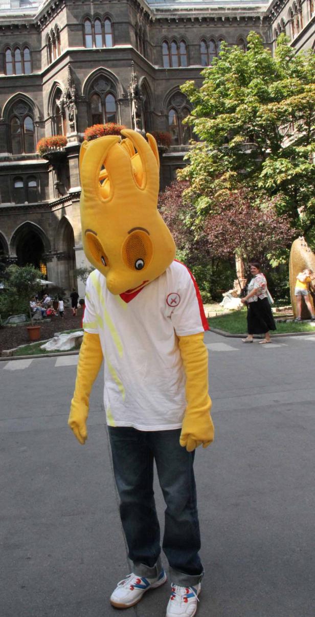 Eine Person im gelben Krakenkostüm steht auf einer Straße.
