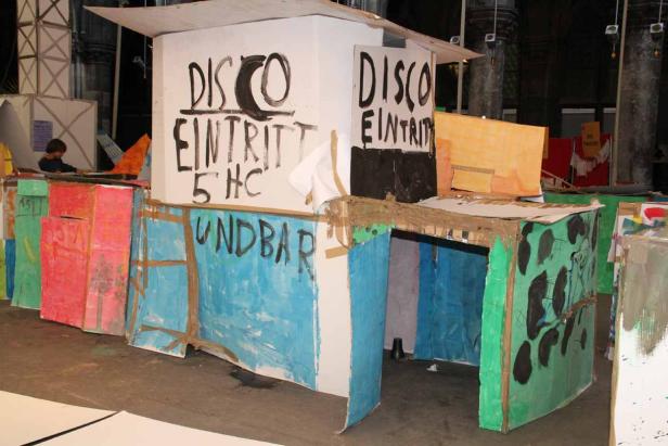 Ein farbenfroher, selbstgebauter Stand mit der Aufschrift „Disco Eintritt 5 HC“.