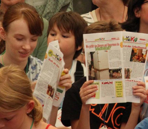 Mehrere Kinder lesen eine Ausgabe der „KiKu“-Zeitung.