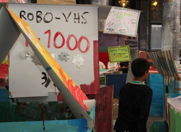 Ein Junge steht vor einer Installation mit der Aufschrift „ROBO-VHS 1000“.