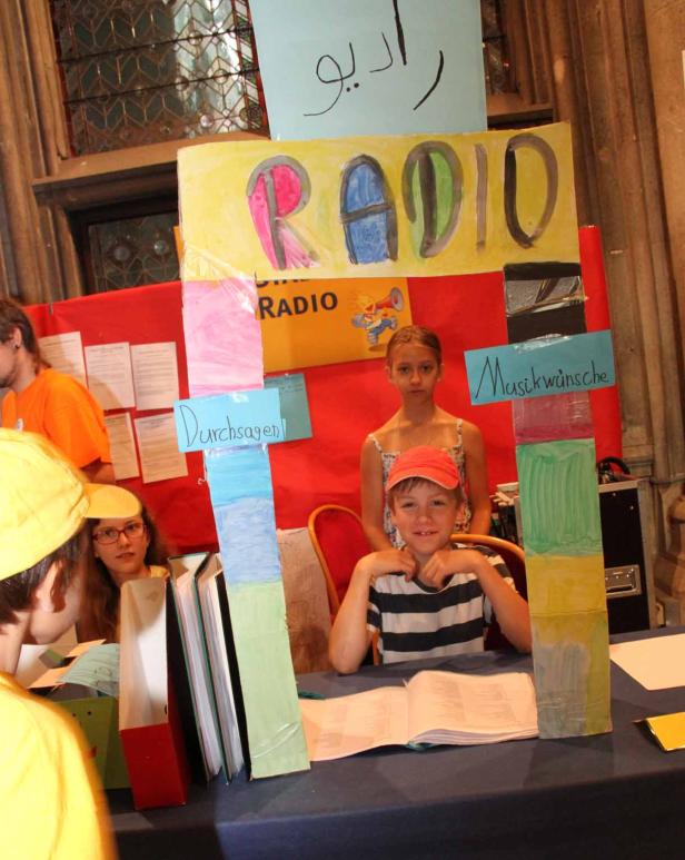 Kinder präsentieren einen selbst gestalteten Radiosender.