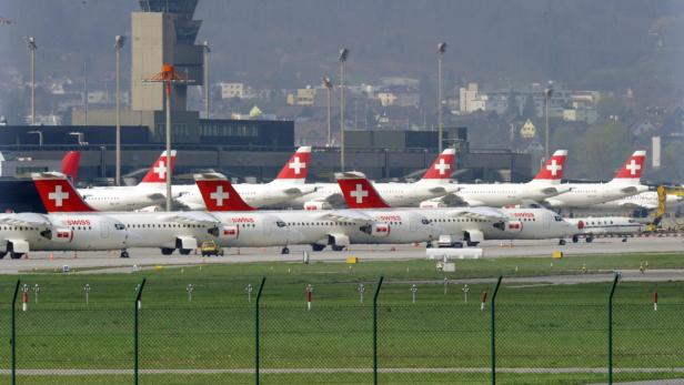 Mehrere Flugzeuge der Swiss stehen auf dem Rollfeld eines Flughafens.