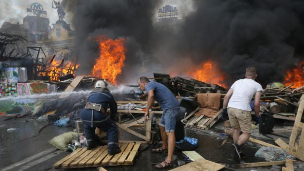 Ein Feuerwehrmann bekämpft einen Brand auf dem Maidan-Platz in Kiew.