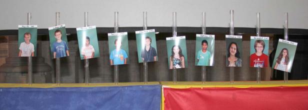 Eine Reihe von Kinderporträts, die auf Ständern befestigt sind.