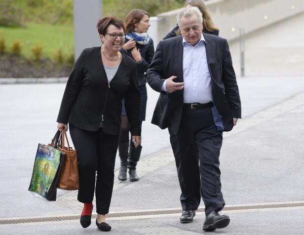 Eine Frau mit Einkaufstaschen und ein Mann im Anzug gehen nebeneinander.