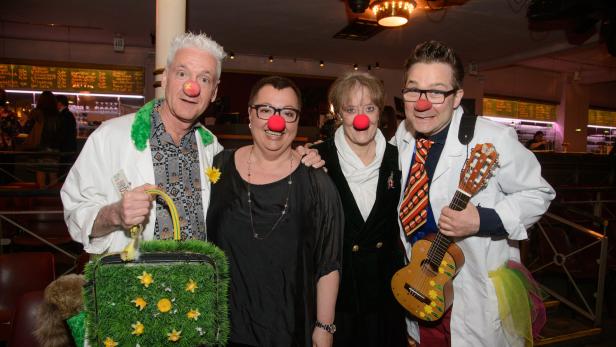 Eine Gruppe von Menschen mit roten Nasen, vermutlich Clowns, posiert für ein Foto.