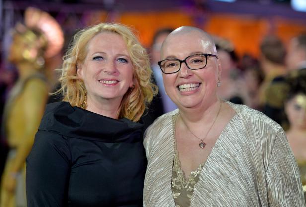 Zwei Frauen lächeln auf einer Veranstaltung in die Kamera.