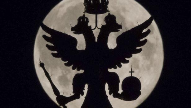 Der russische Doppeladler als Silhouette vor einem Vollmond.