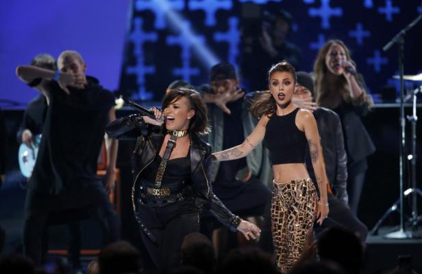 Demi Lovato tritt mit Tänzern auf einer Bühne auf.