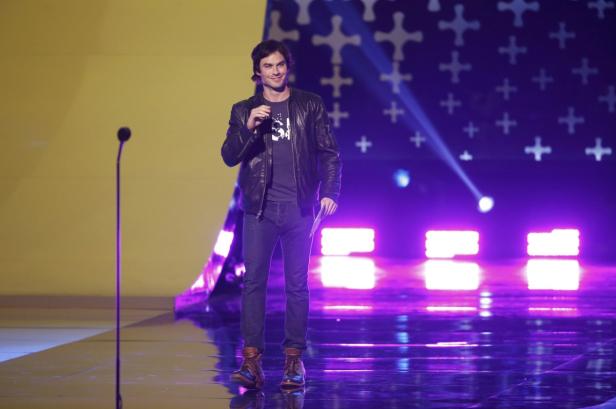 Ian Somerhalder steht auf einer Bühne mit Mikrofon und lacht.