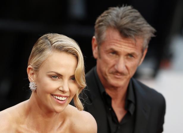 Charlize Theron und Sean Penn posieren auf einem roten Teppich.