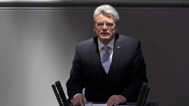 Ein Mann in einem Anzug steht an einem Rednerpult.