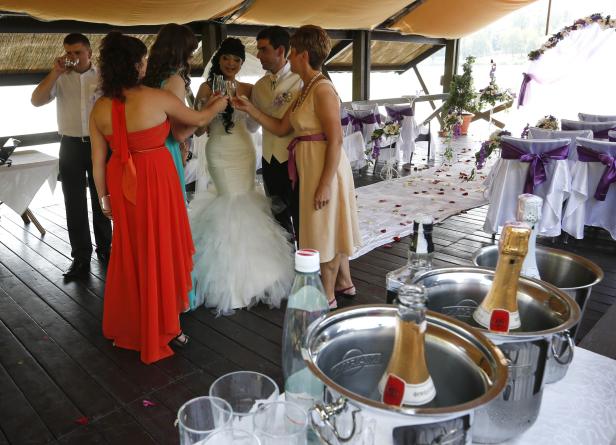 Eine Hochzeitsgesellschaft stößt mit Sektgläsern an.