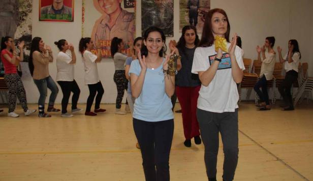 Eine Gruppe junger Frauen tanzt und klatscht in einem Raum.