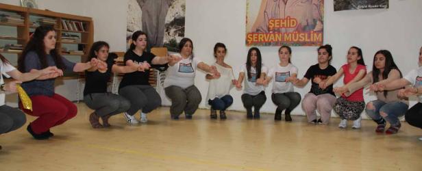 Eine Gruppe junger Frauen hockt im Kreis und hält sich an den Händen.