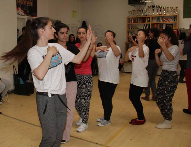Eine Gruppe junger Frauen tanzt in einem Raum mit Holzboden.