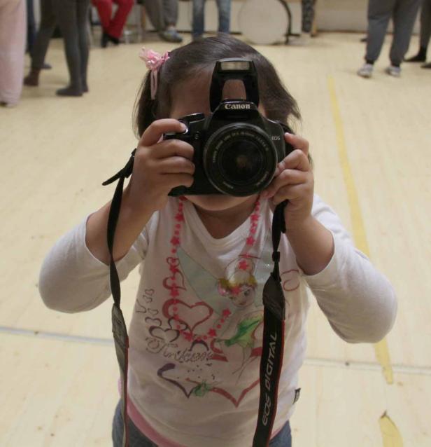 Ein kleines Mädchen fotografiert mit einer Canon EOS Kamera.