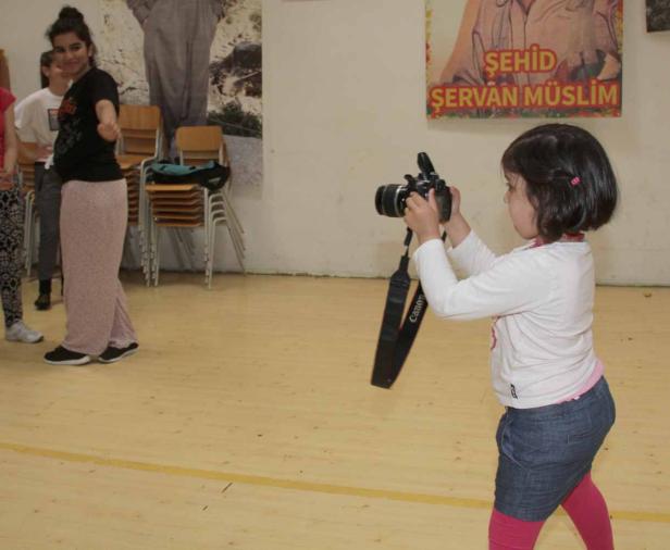 Ein kleines Mädchen fotografiert mit einer Spiegelreflexkamera.