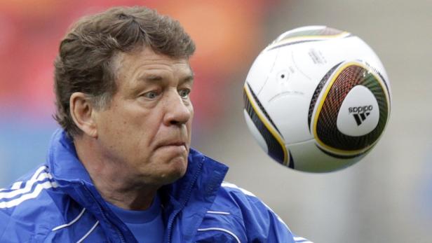 Ein Mann in blauer Jacke blickt auf einen Adidas-Fußball.