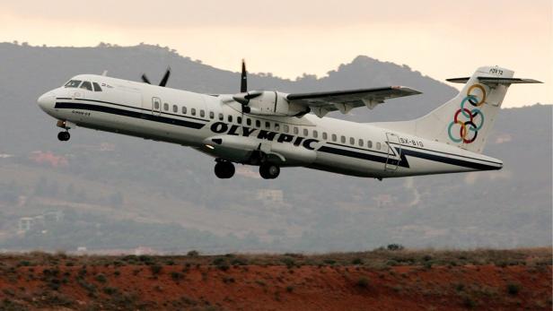 Ein Flugzeug der Olympic Airways startet vor einer Hügellandschaft.