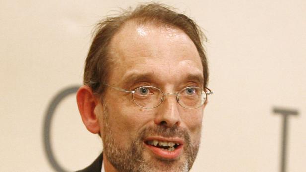 Heinz Fassmann, der Vorsitzende des Expertenrats. Ein Mann mit Brille und Bart lächelt.