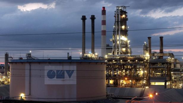 Eine beleuchtete Industrieanlage der OMV bei Dämmerung.