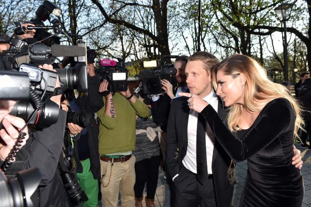 Ein Paar steht vor einer Gruppe von Fotografen und Kameraleuten.