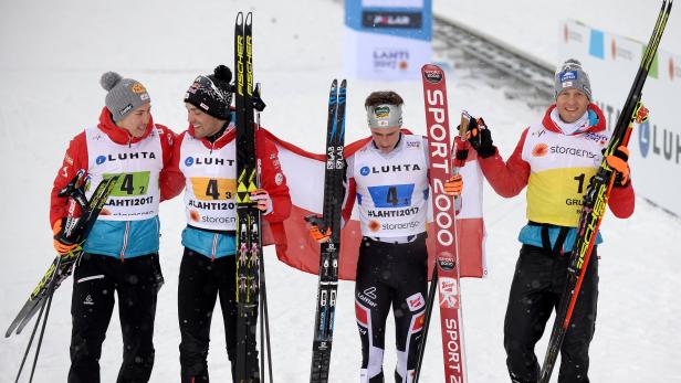 Österreichische Skilangläufer feiern mit der österreichischen Flagge bei einem Wettbewerb in Lahti 2017.