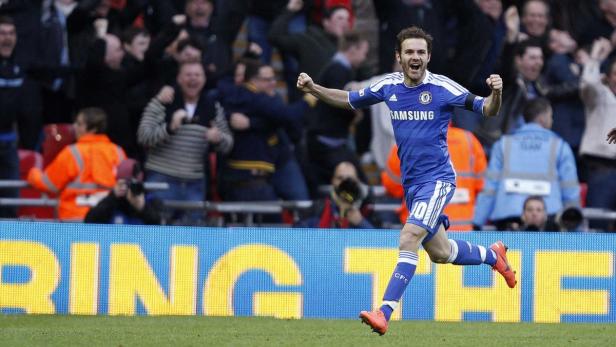 Ein jubelnder Fußballspieler im blauen Trikot rennt über den Rasen.