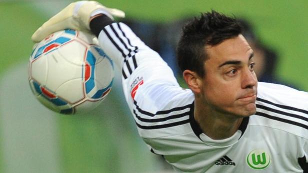 Ein Fußballtorwart fängt einen Ball mit seiner behandschuhten Hand.